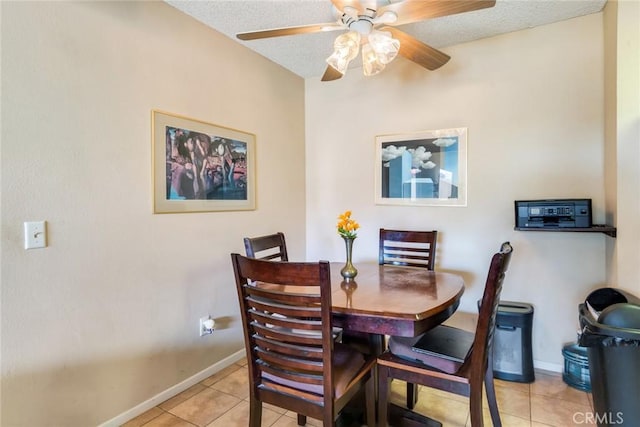 dining space featuring light tile patterned floors, a textured ceiling, and baseboards