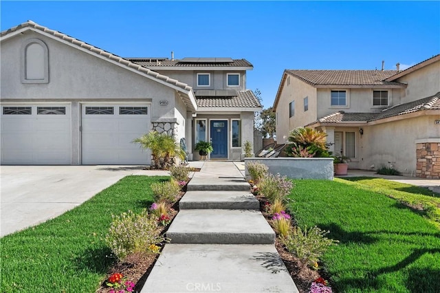 view of front of house with stucco siding, solar panels, an attached garage, driveway, and a front lawn