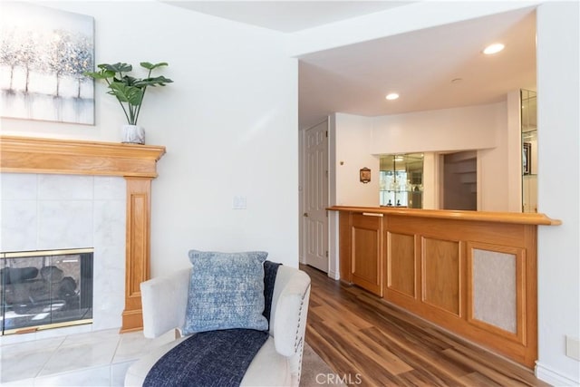 living area featuring a tile fireplace, recessed lighting, and wood finished floors