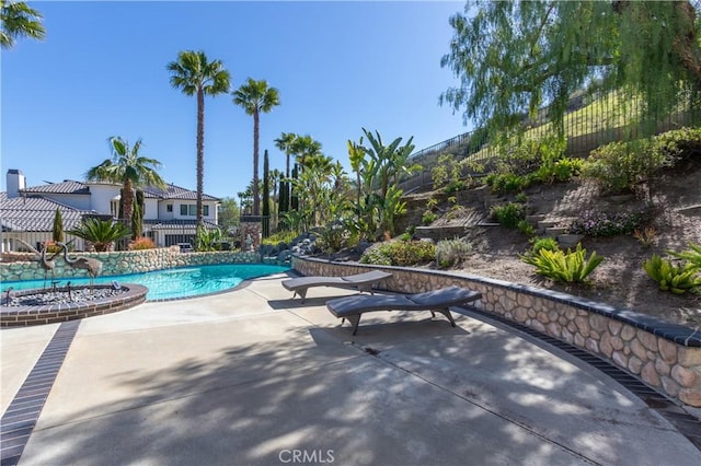 outdoor pool featuring a patio area and fence