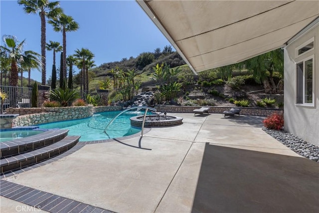 view of pool with a pool with connected hot tub, a patio area, and fence