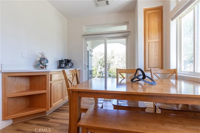 dining space featuring visible vents and wood finished floors