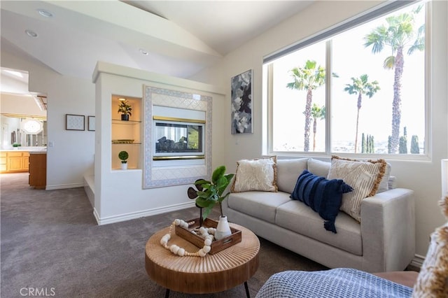 carpeted living room with built in shelves, lofted ceiling, and baseboards