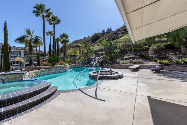 view of pool featuring a pool with connected hot tub, a patio area, and fence