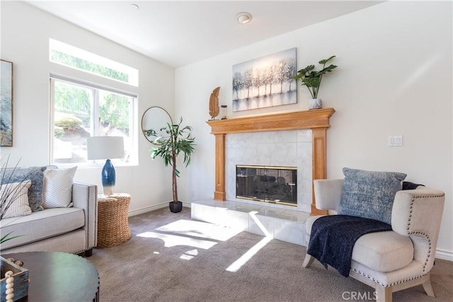 carpeted living area featuring baseboards and a high end fireplace