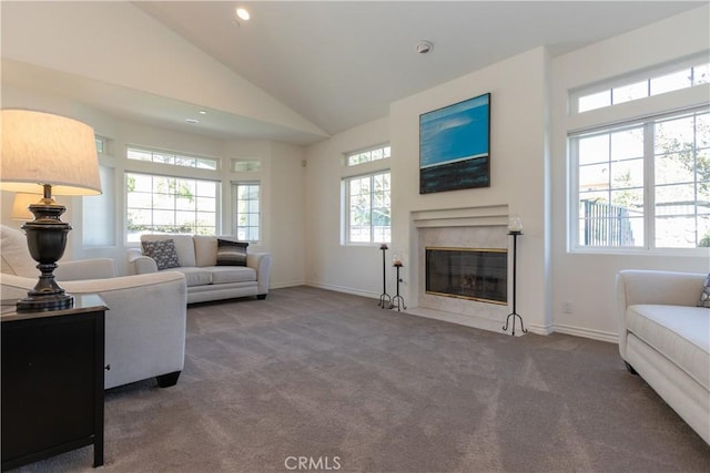 living area featuring high vaulted ceiling, carpet flooring, a high end fireplace, and baseboards