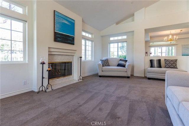 carpeted living area with high vaulted ceiling, a high end fireplace, a notable chandelier, and baseboards