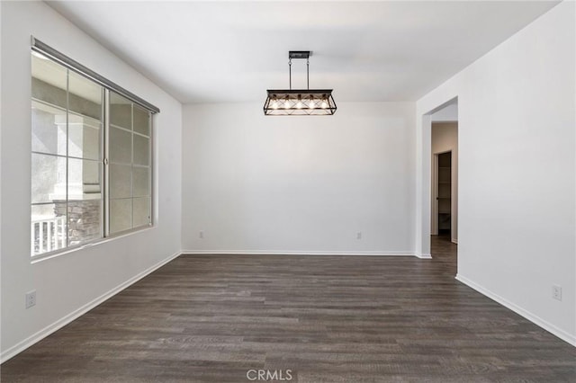 empty room with dark wood-style floors and baseboards