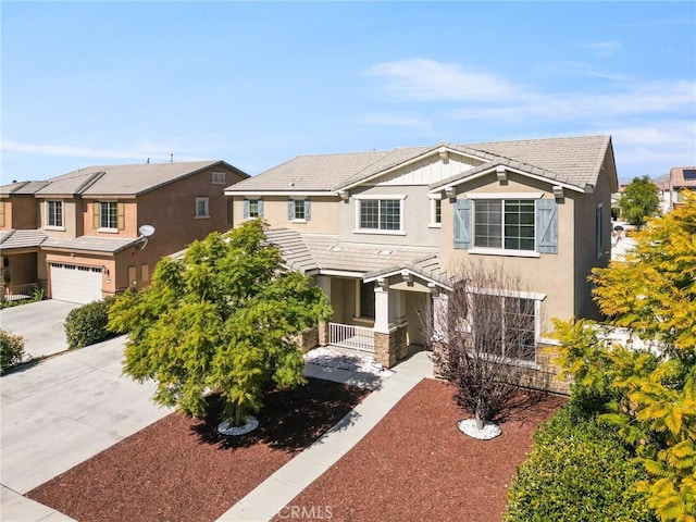 traditional home featuring a garage, concrete driveway, a residential view, a tiled roof, and stucco siding