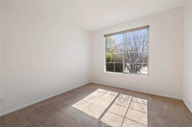 unfurnished room with carpet flooring and baseboards