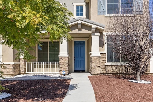 entrance to property with stone siding and stucco siding