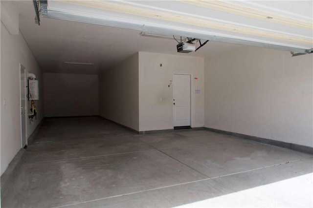 garage with baseboards, water heater, and a garage door opener