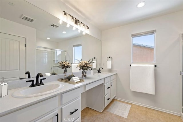 bathroom featuring visible vents, a sink, a shower stall, and double vanity