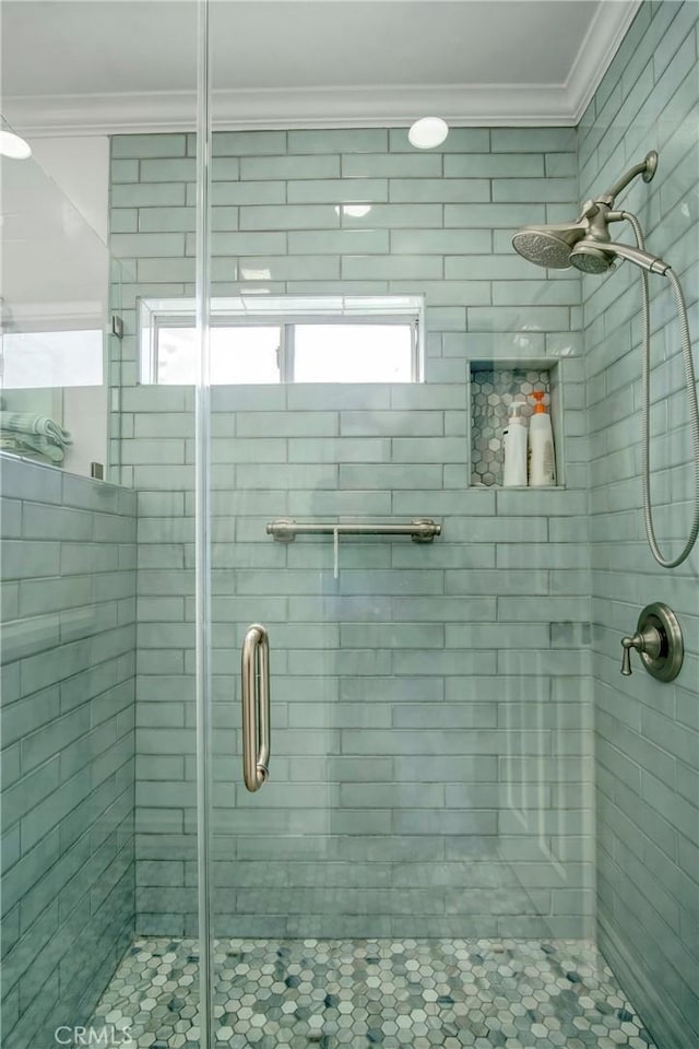 full bath with a shower stall and crown molding
