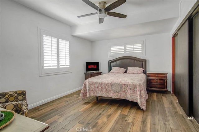 bedroom with hardwood / wood-style floors, baseboards, a closet, and ceiling fan