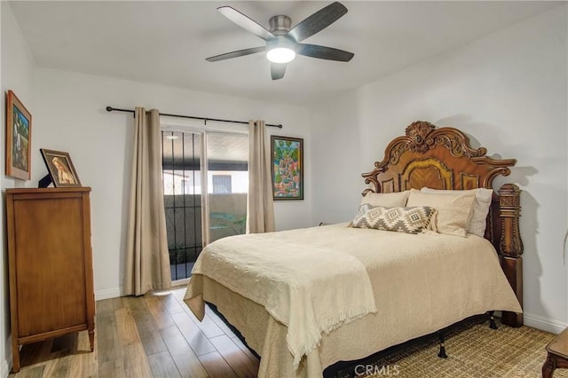 bedroom featuring wood finished floors, baseboards, a ceiling fan, and access to exterior