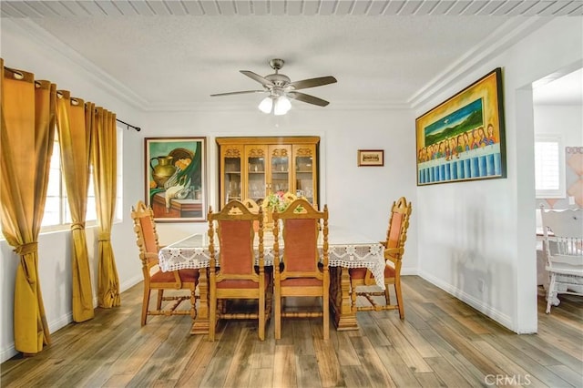 dining room with a ceiling fan, baseboards, and wood-type flooring