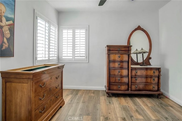 bedroom with light wood-style floors, a ceiling fan, and baseboards