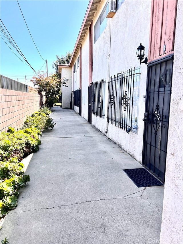 exterior space featuring stucco siding and fence