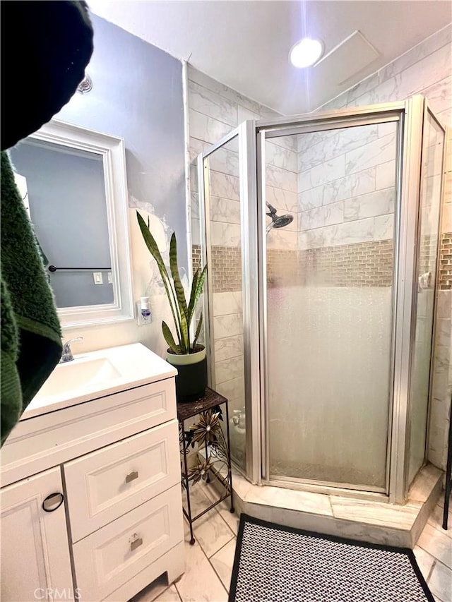 bathroom featuring vanity, a stall shower, and marble finish floor