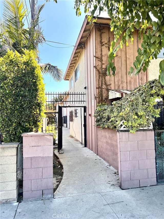 view of side of home with stucco siding and fence