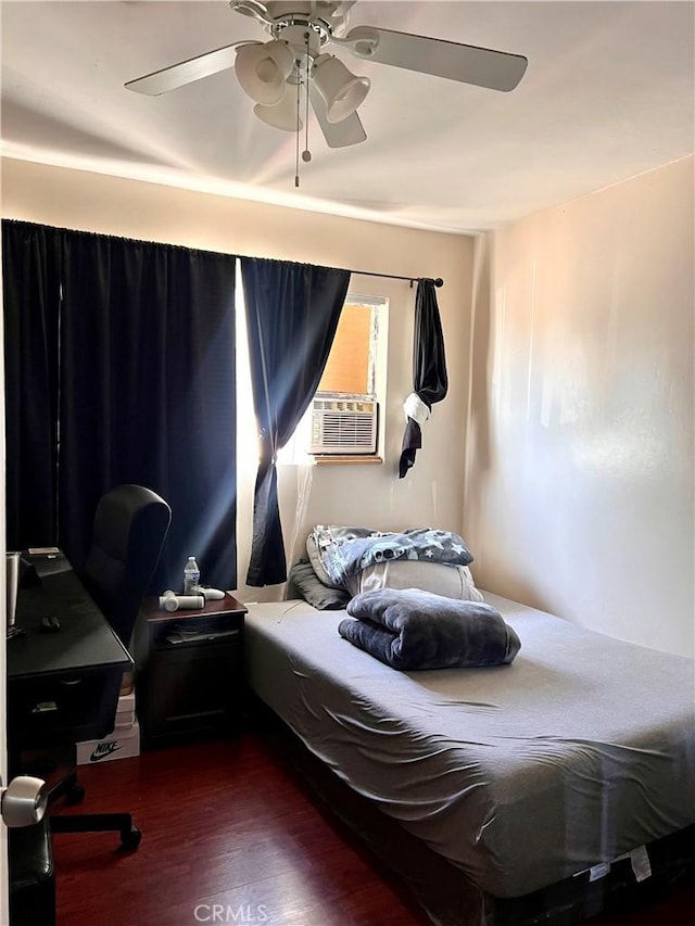 bedroom with cooling unit, a ceiling fan, and wood finished floors