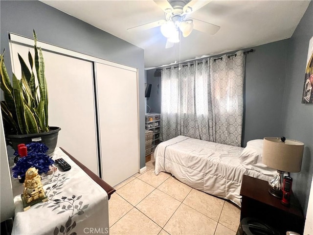 bedroom with light tile patterned floors, ceiling fan, and a closet