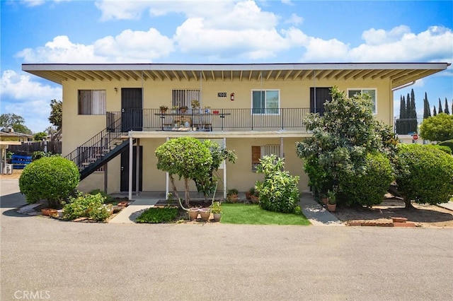 view of front of home with stairs and stucco siding