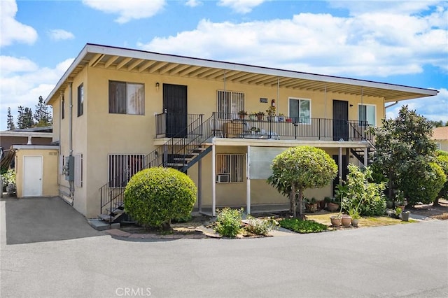 view of front of property with stairway and stucco siding