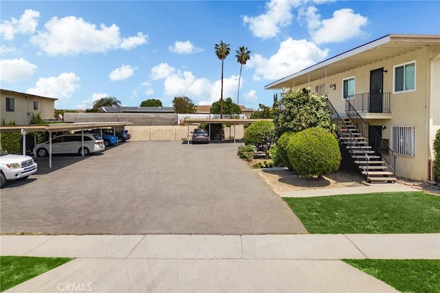 covered parking lot featuring stairway