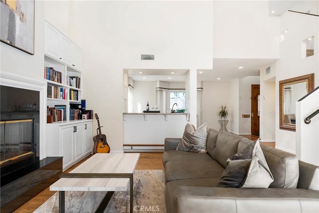17846 Palora St, Encino, CA 91316 - living area featuring a towering ceiling, wood finished floors, visible vents, and baseboard heating