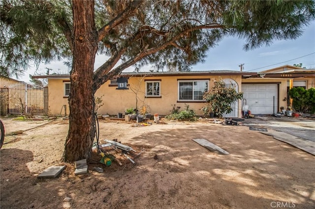 ranch-style home with a garage, driveway, and stucco siding