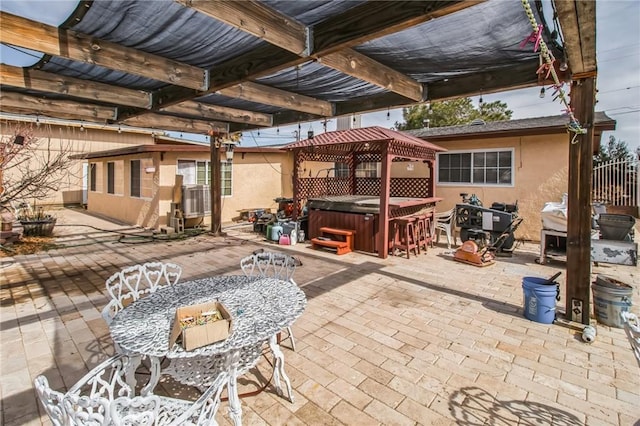 view of patio / terrace with a gazebo, a hot tub, and outdoor dining space