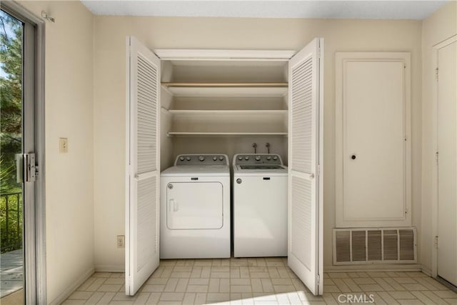 clothes washing area with laundry area, independent washer and dryer, visible vents, and baseboards