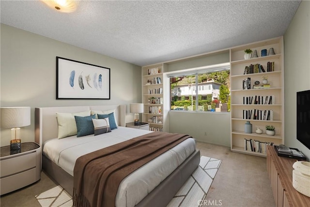 bedroom with a textured ceiling and light colored carpet