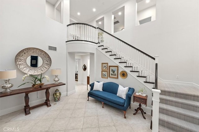 stairway with visible vents, tile patterned floors, baseboards, recessed lighting, and arched walkways