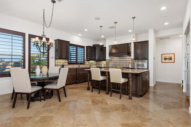 kitchen featuring extractor fan, visible vents, stainless steel oven, dark brown cabinets, and decorative backsplash