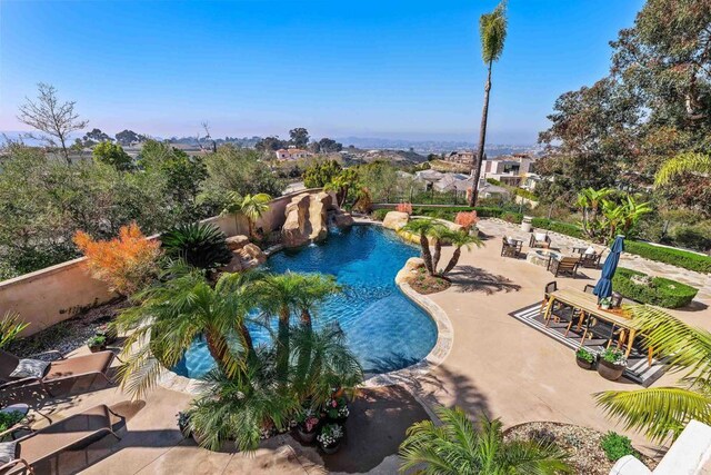 pool with a patio and fence