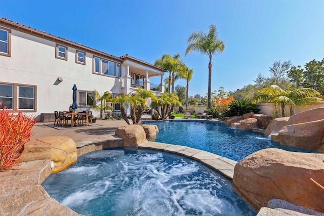 outdoor pool featuring an in ground hot tub and a patio area