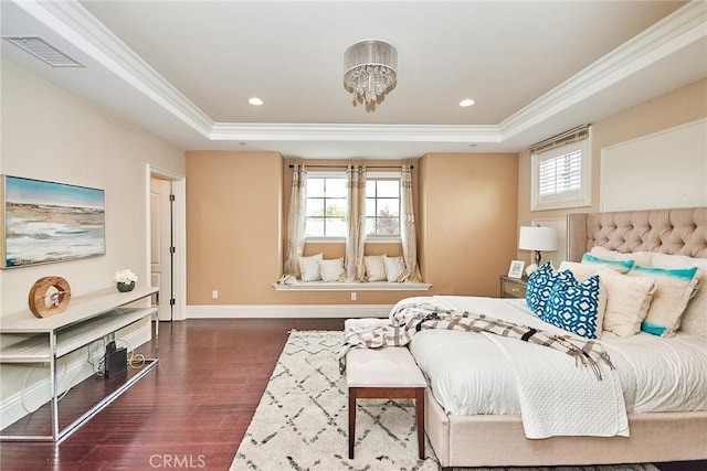 bedroom with wood finished floors, a raised ceiling, visible vents, and crown molding