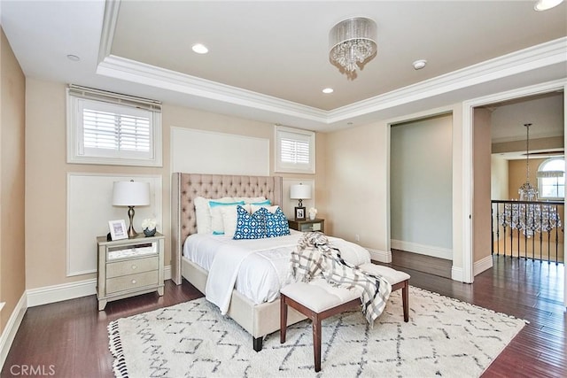 bedroom with a chandelier, a tray ceiling, and wood finished floors