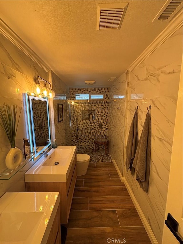 bathroom featuring toilet, visible vents, walk in shower, and a textured ceiling