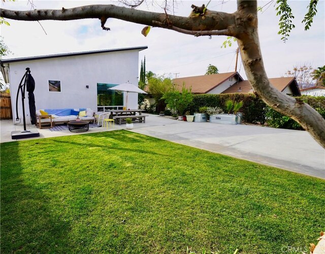 view of yard featuring an outdoor hangout area, a patio area, and fence