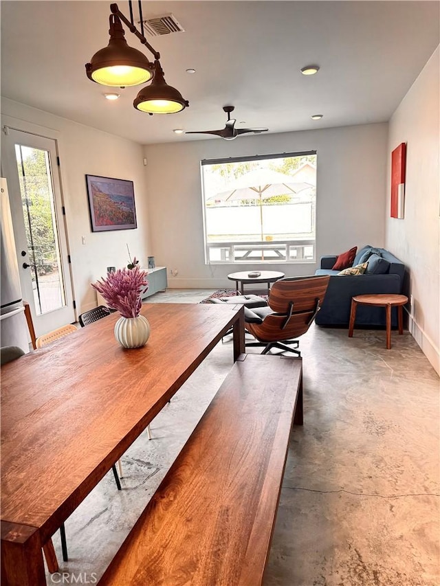 dining area with a ceiling fan, concrete floors, visible vents, and a wealth of natural light