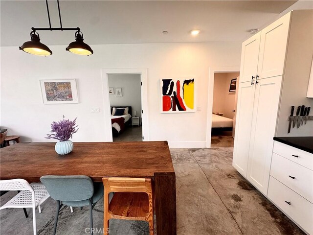 dining room with concrete flooring and baseboards