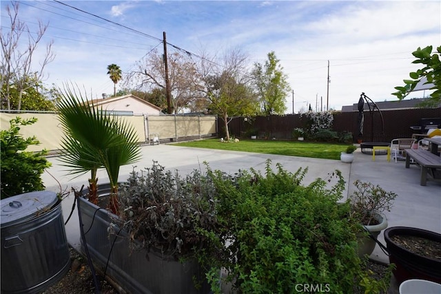 view of yard featuring central AC unit, a patio area, and a fenced backyard