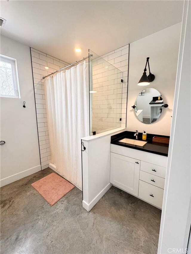 bathroom with concrete flooring, a shower with curtain, vanity, and baseboards