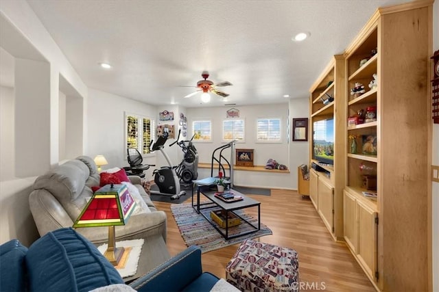 living area featuring a textured ceiling, light wood finished floors, a ceiling fan, and recessed lighting