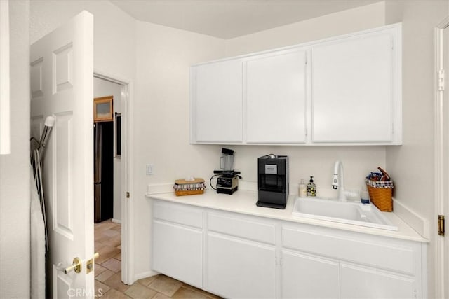 bar featuring a sink and freestanding refrigerator