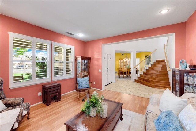 living area featuring recessed lighting, visible vents, wood finished floors, baseboards, and stairs